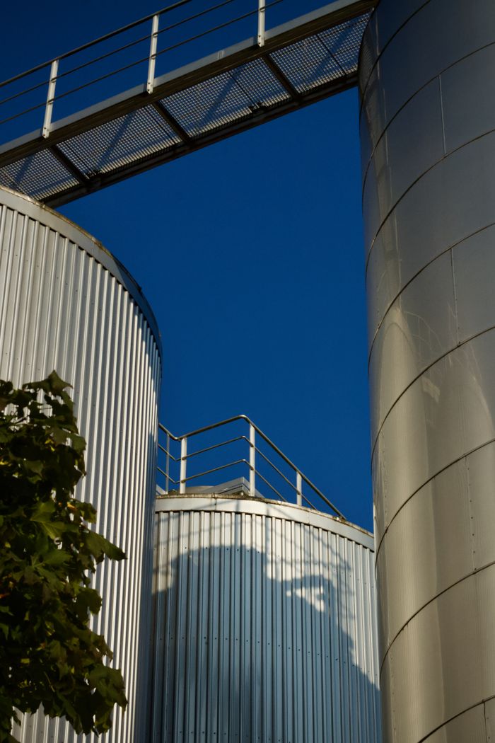 Close-up of industrial silos with a blue sky backdrop, showcasing modern architecture.